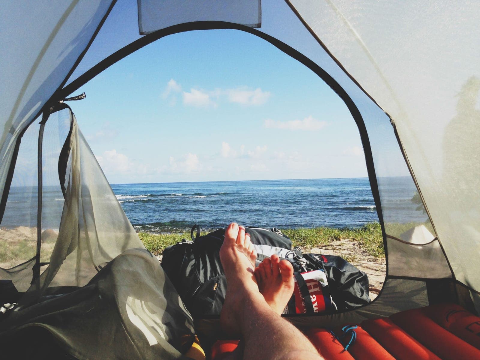 The view out of an open tent door toward the ocean